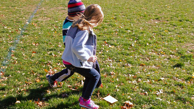 Kids run to paper shape on ground